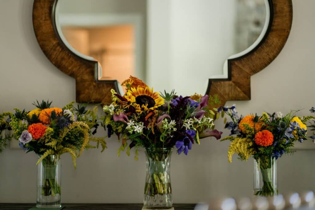 Sun Flower Hill Farm sunflowers and marigolds in clear vases wedding decor